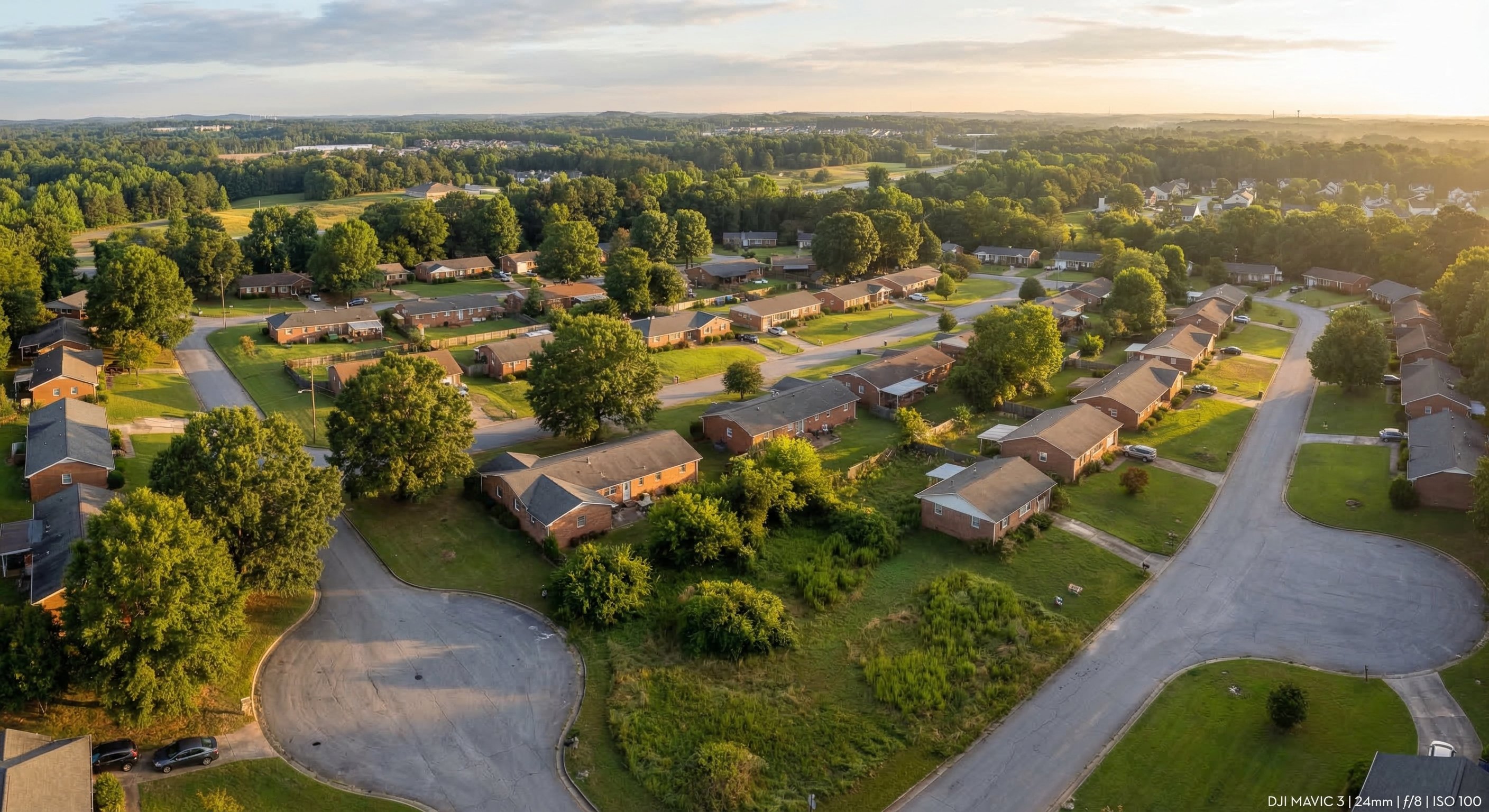 Aerial drone view of metro Atlanta suburban residential neighborhoods showing dense brick ranch homes and tree-lined streets