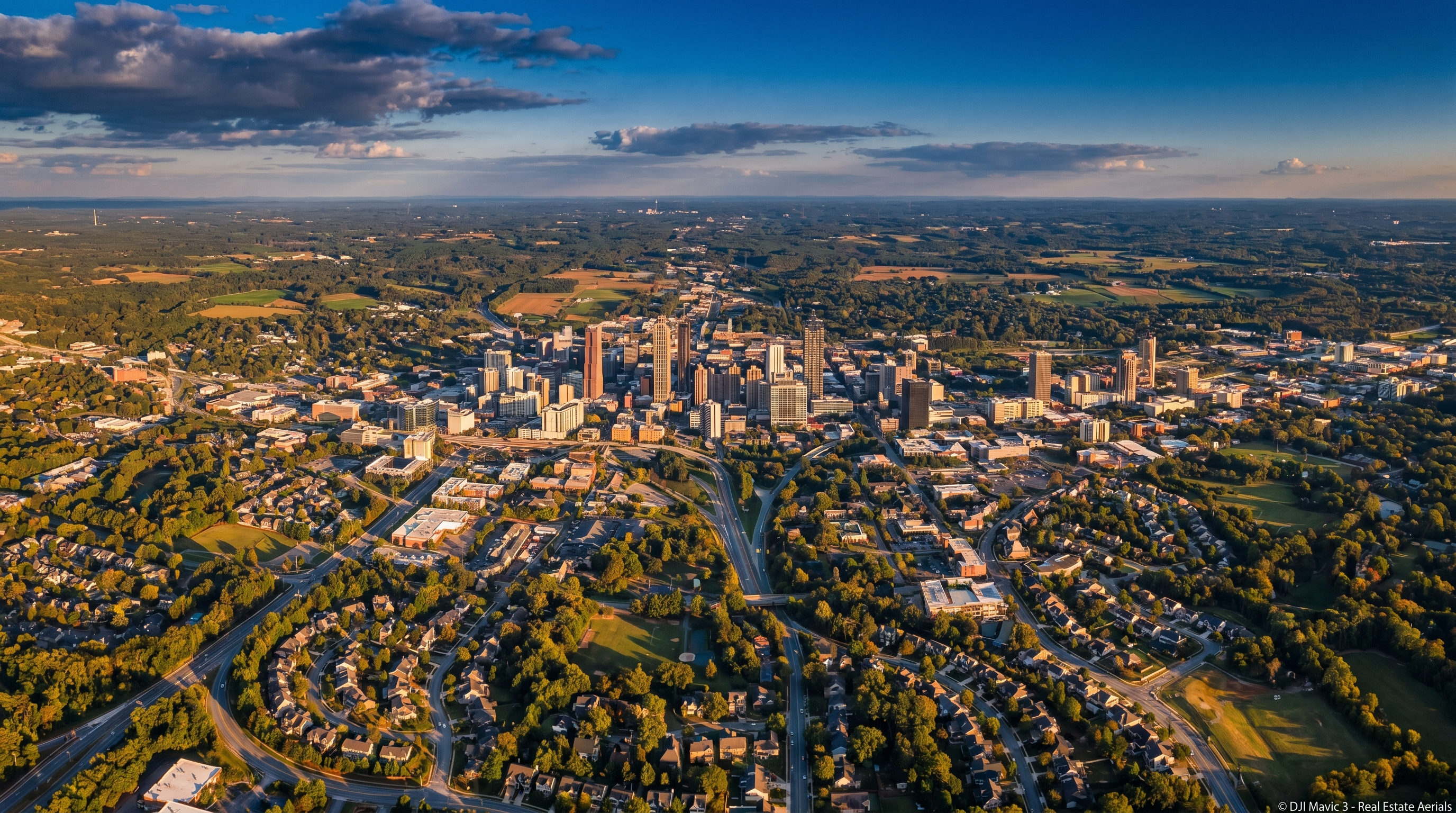 Aerial view of Atlanta metropolitan area at golden hour, showing dense urban core radiating outward to suburban and rural Georgia