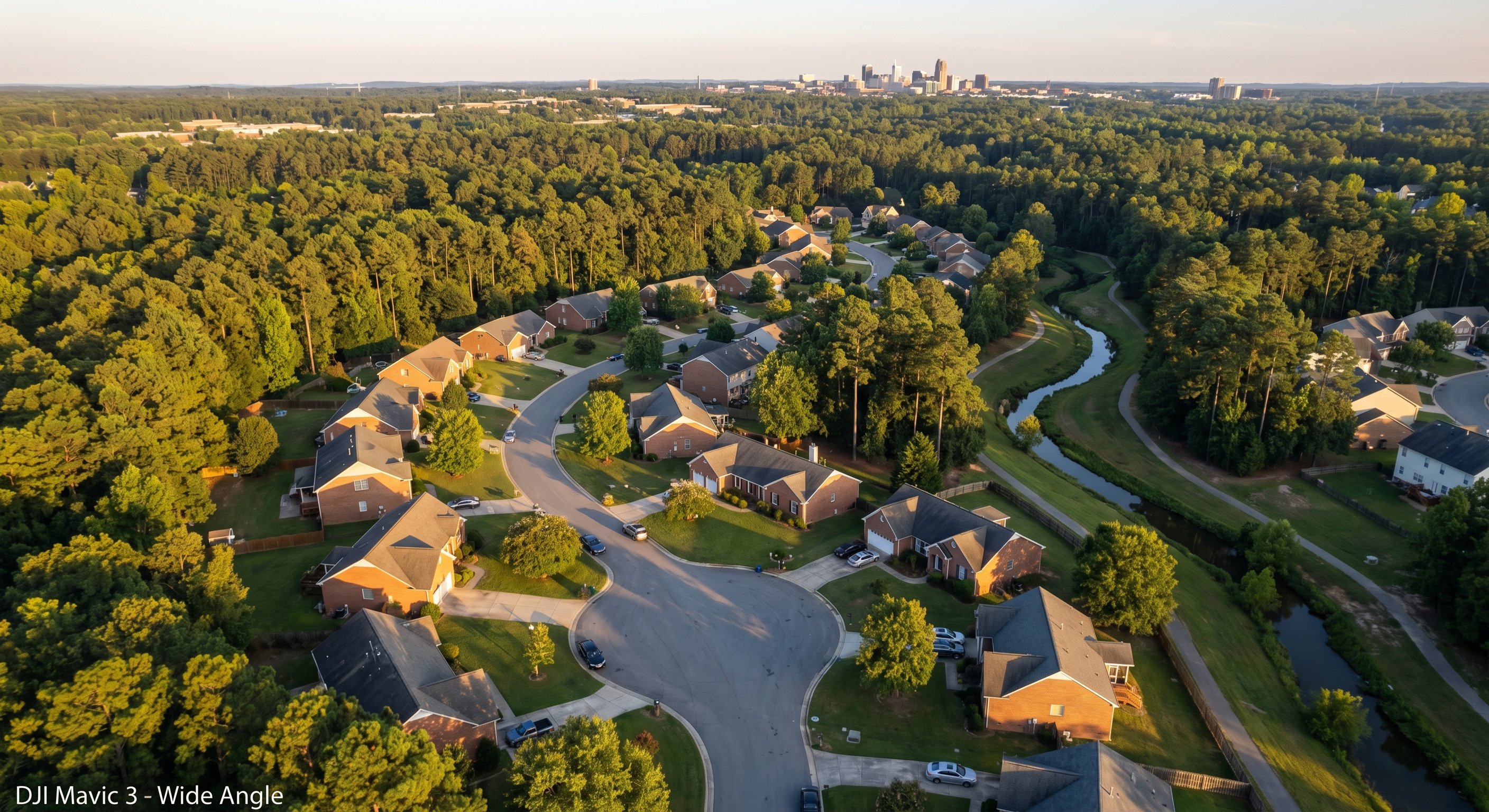 Aerial view of a North Carolina suburban neighborhood with brick ranch homes and mature pines