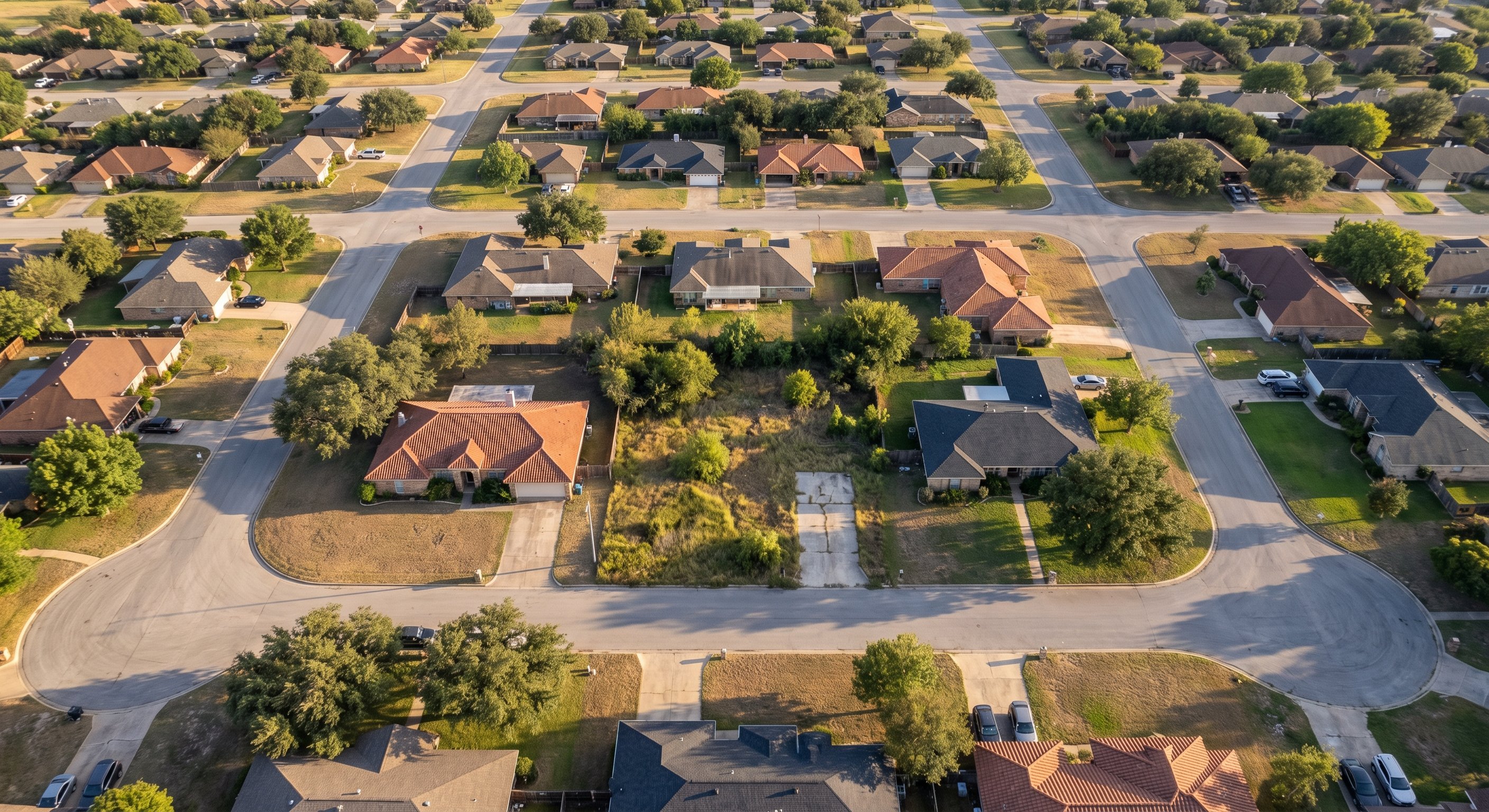 Aerial drone view of suburban Texas neighborhood showing varied property conditions