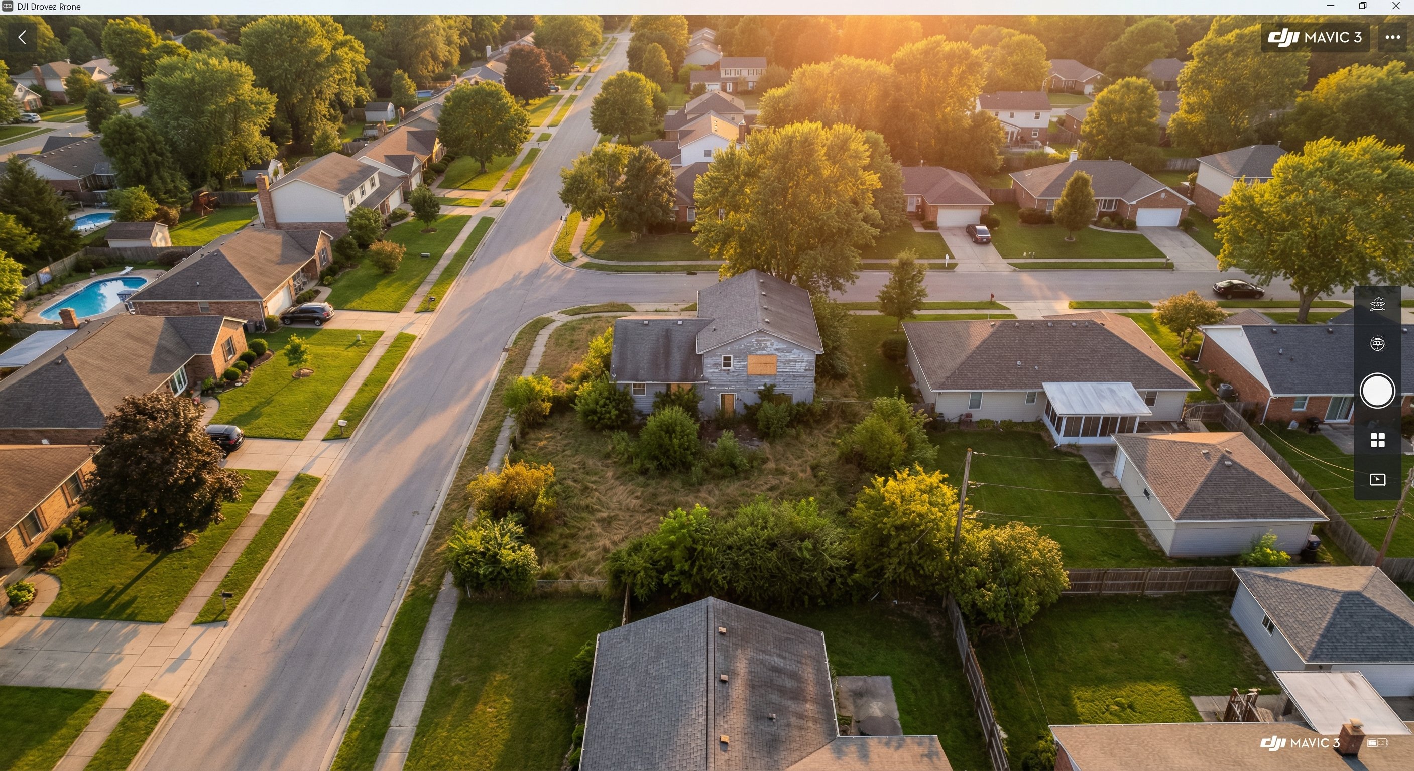 An aerial drone view of a neighborhood with one clearly distressed property visible among well-maintained homes