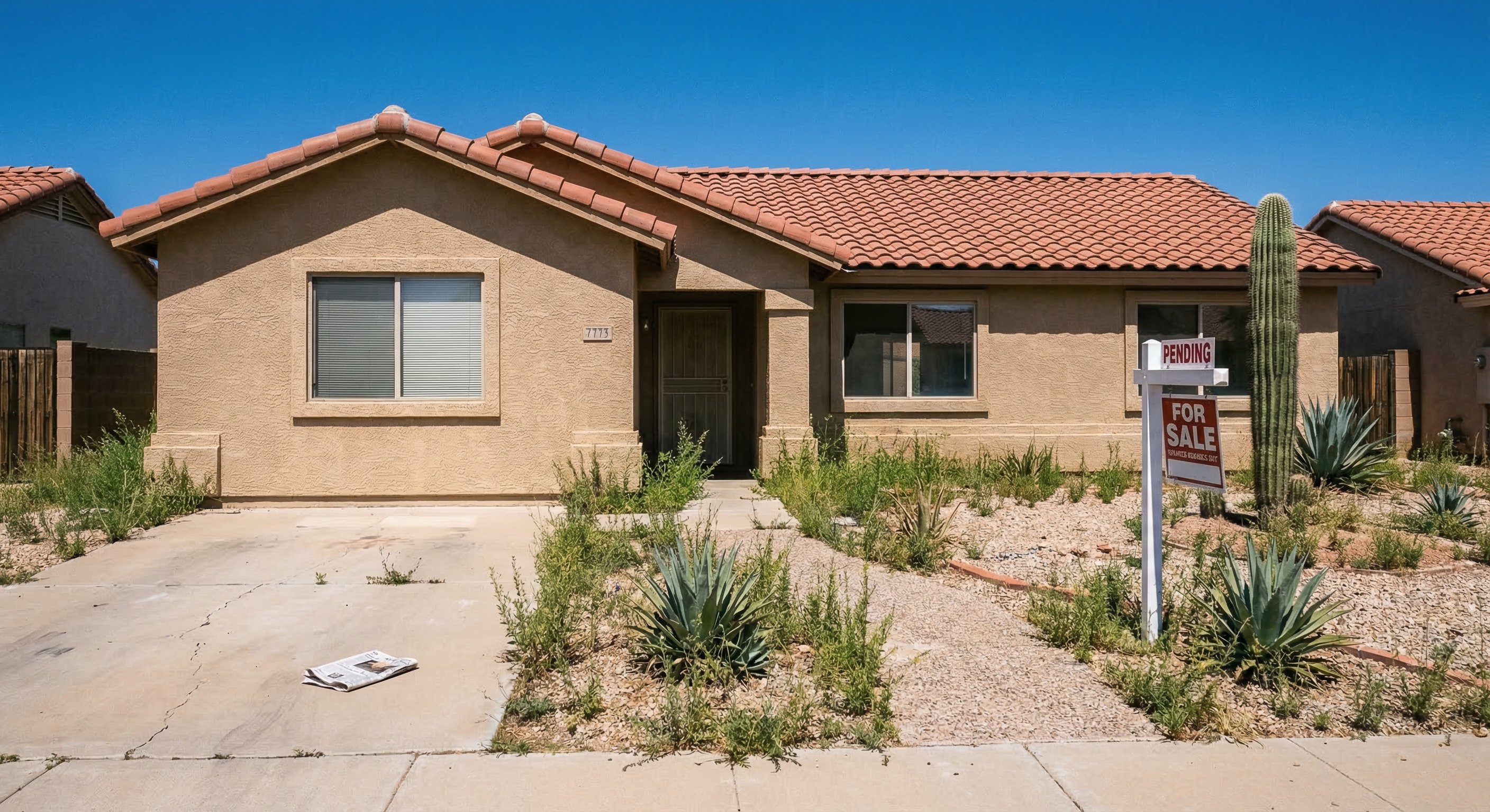 Vacant Arizona stucco ranch home with desert landscaping showing signs of transitional ownership