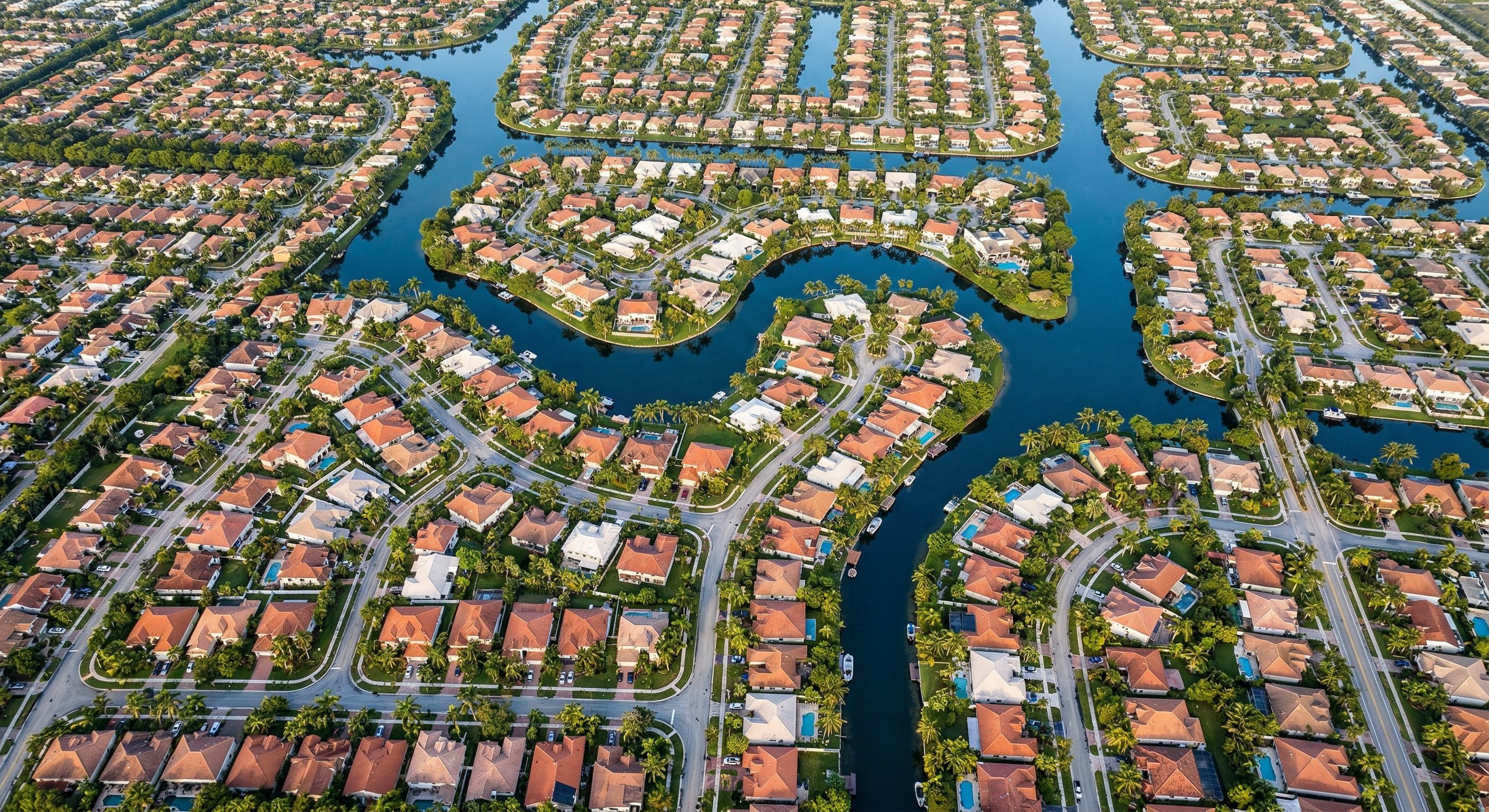 Aerial view of South Florida coastal neighborhoods with dense residential development and waterways visible, showing Miami-Dade and Broward county housing patterns