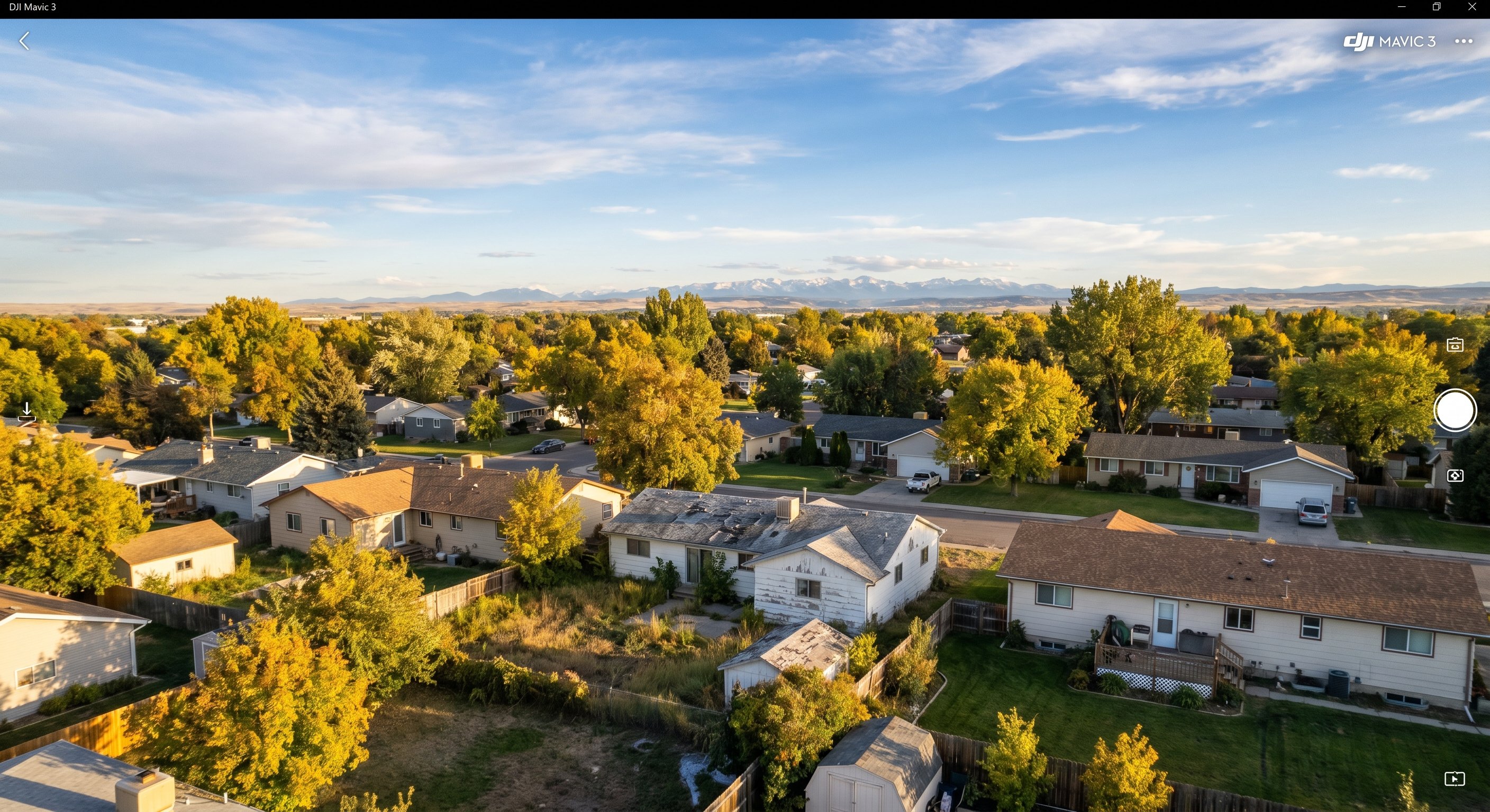 Aerial photograph of a Billings Montana neighborhood with ranch homes, mature trees, and the Beartooth Mountains in the background