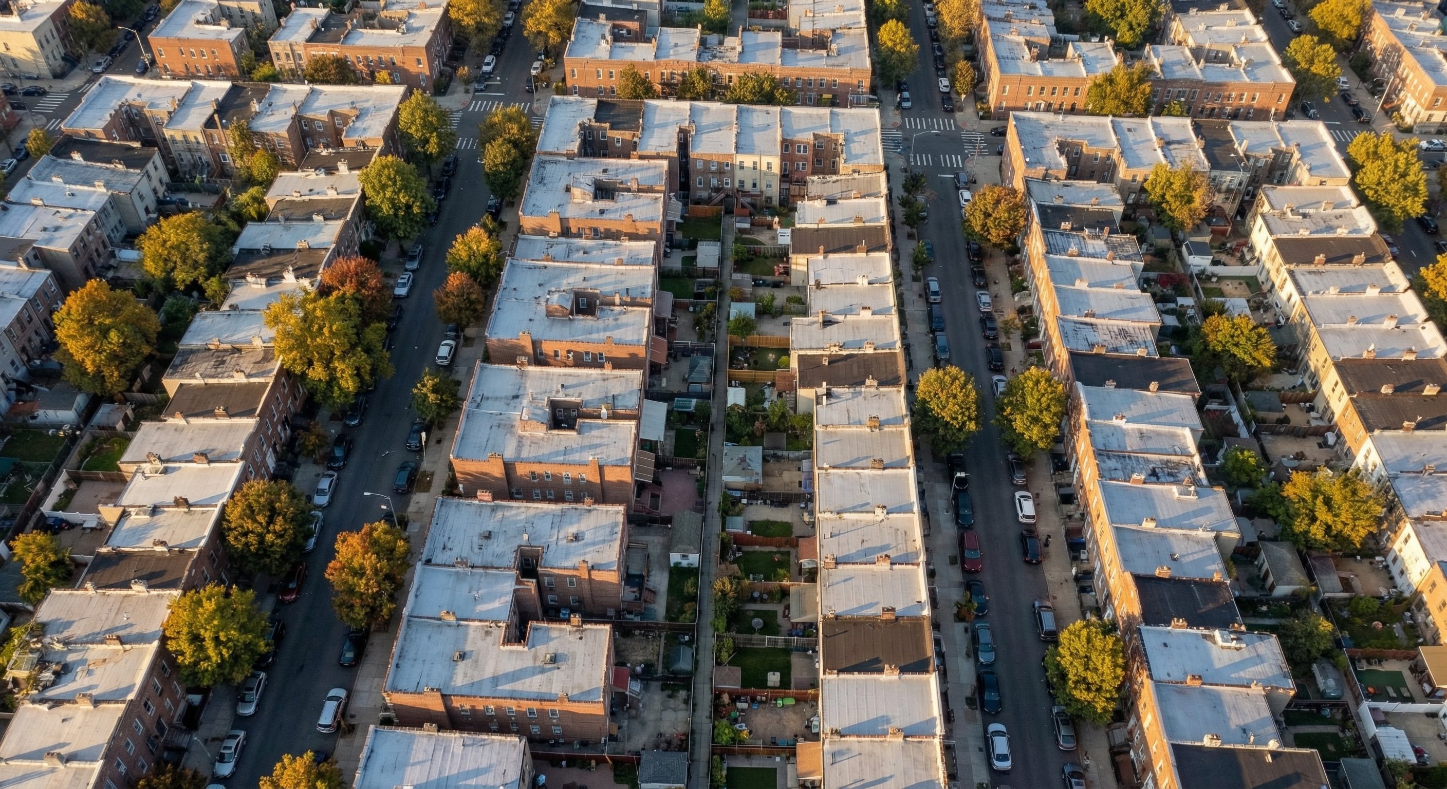 Aerial view of a dense New York residential neighborhood with brick row houses and narrow streets typical of NYC outer boroughs