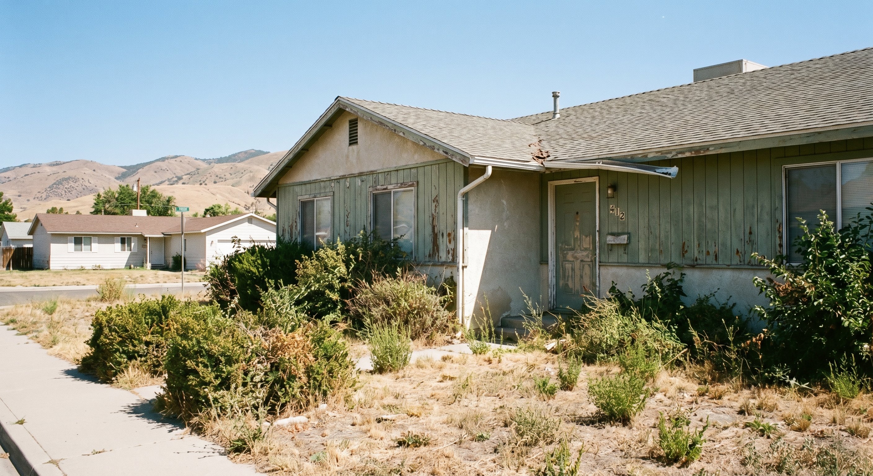 Utah home showing visible deferred maintenance, peeling paint and overgrown yard indicating foreclosure or distress