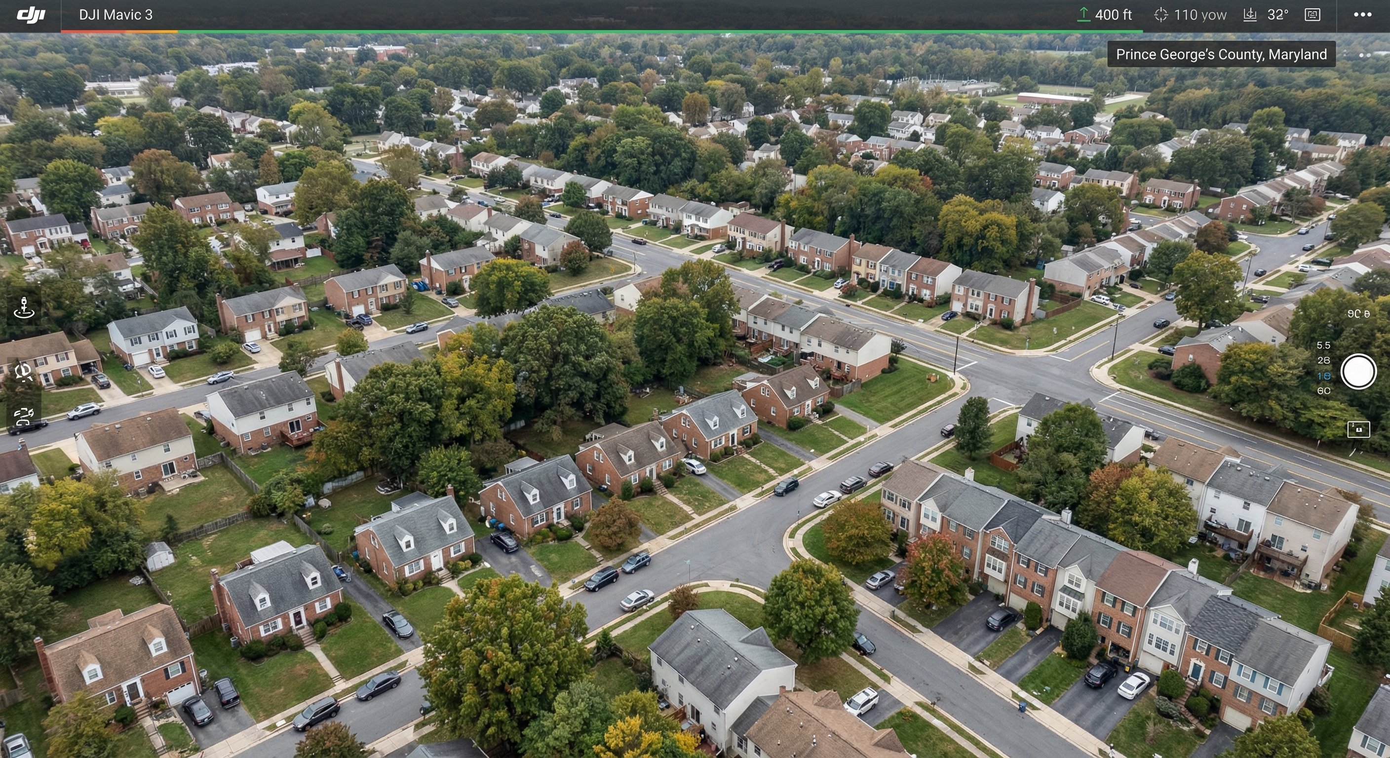 Aerial drone view of Prince George's County Maryland suburban neighborhood with split-level homes, townhouses, and mature tree canopy