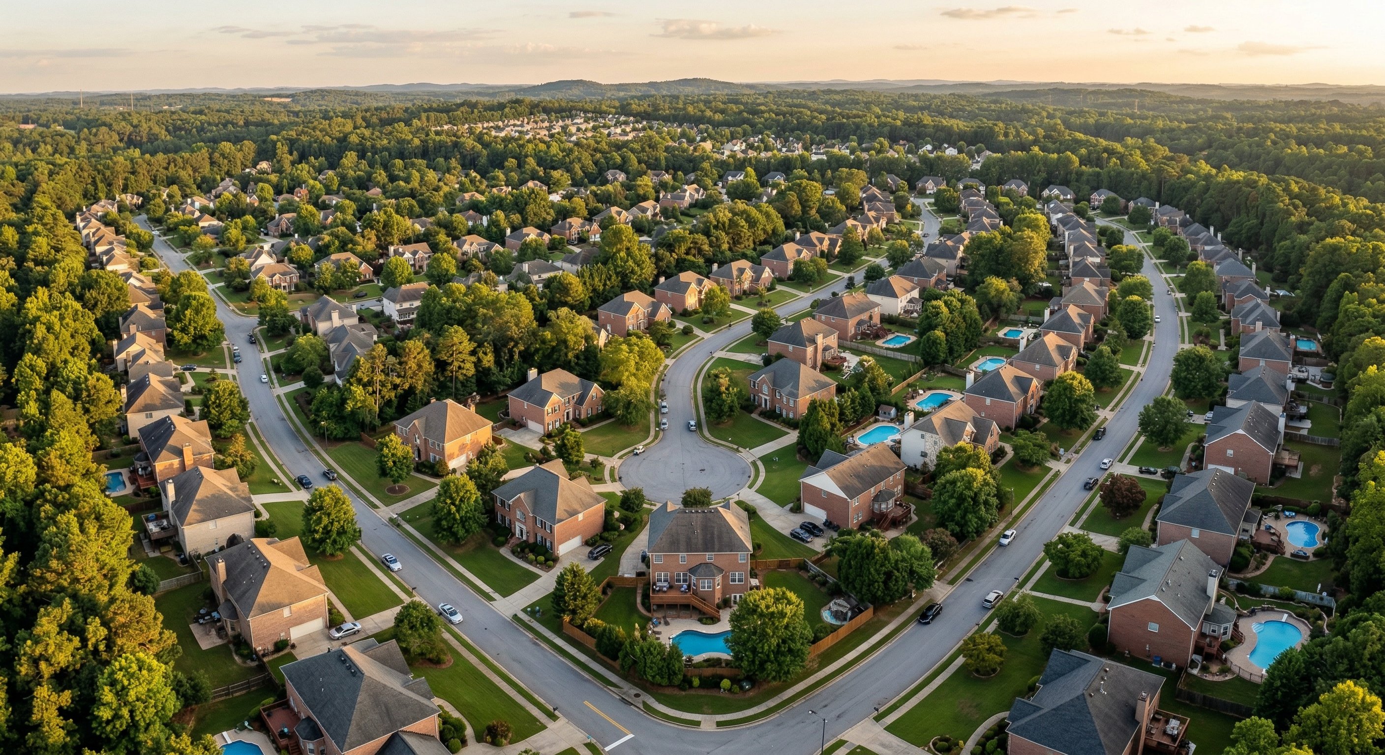 Aerial view of Atlanta metro suburbs — Gwinnett and Fulton County residential neighborhoods at golden hour, drone shot from 300 feet showing suburban density and tree-lined streets