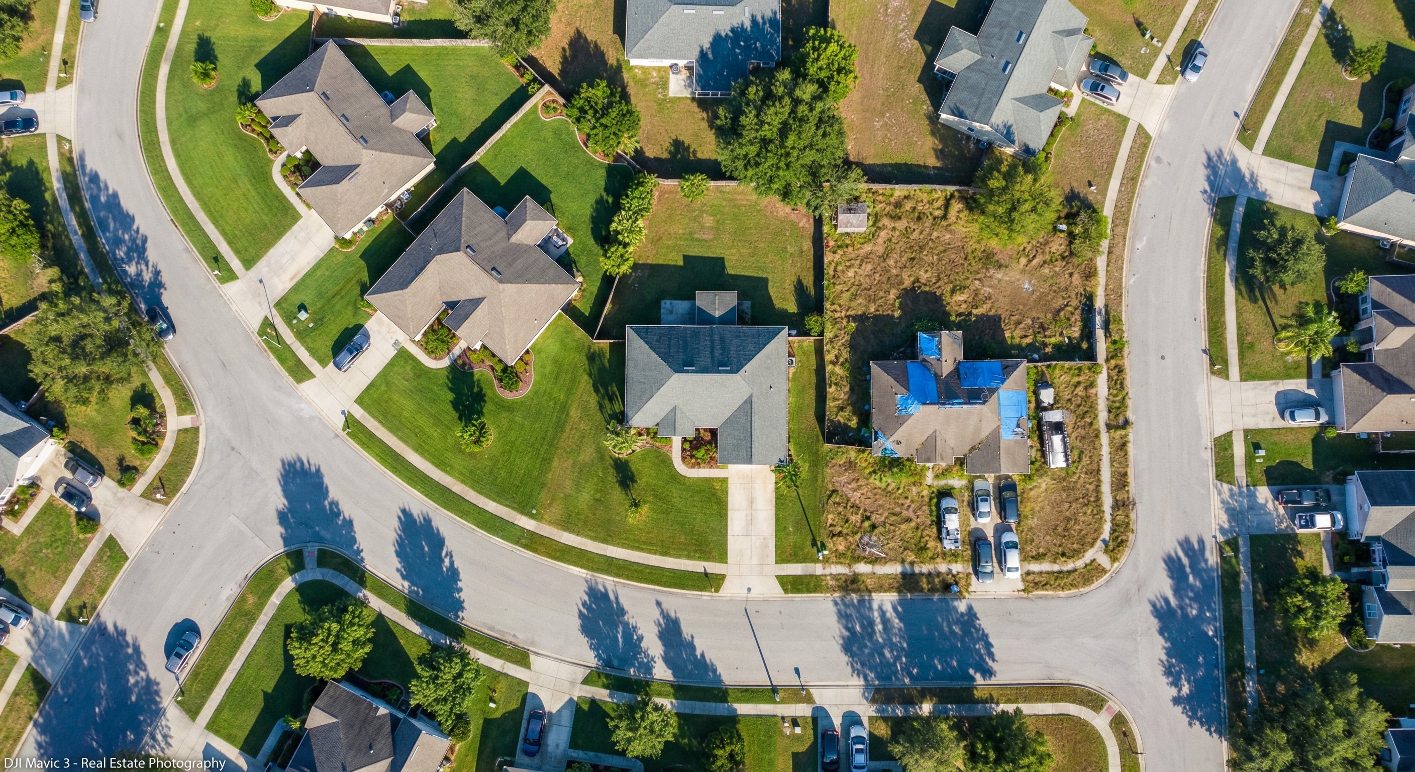 Aerial view of a suburban neighborhood showing mixed property conditions, highlighting how REO inventory appears in clusters