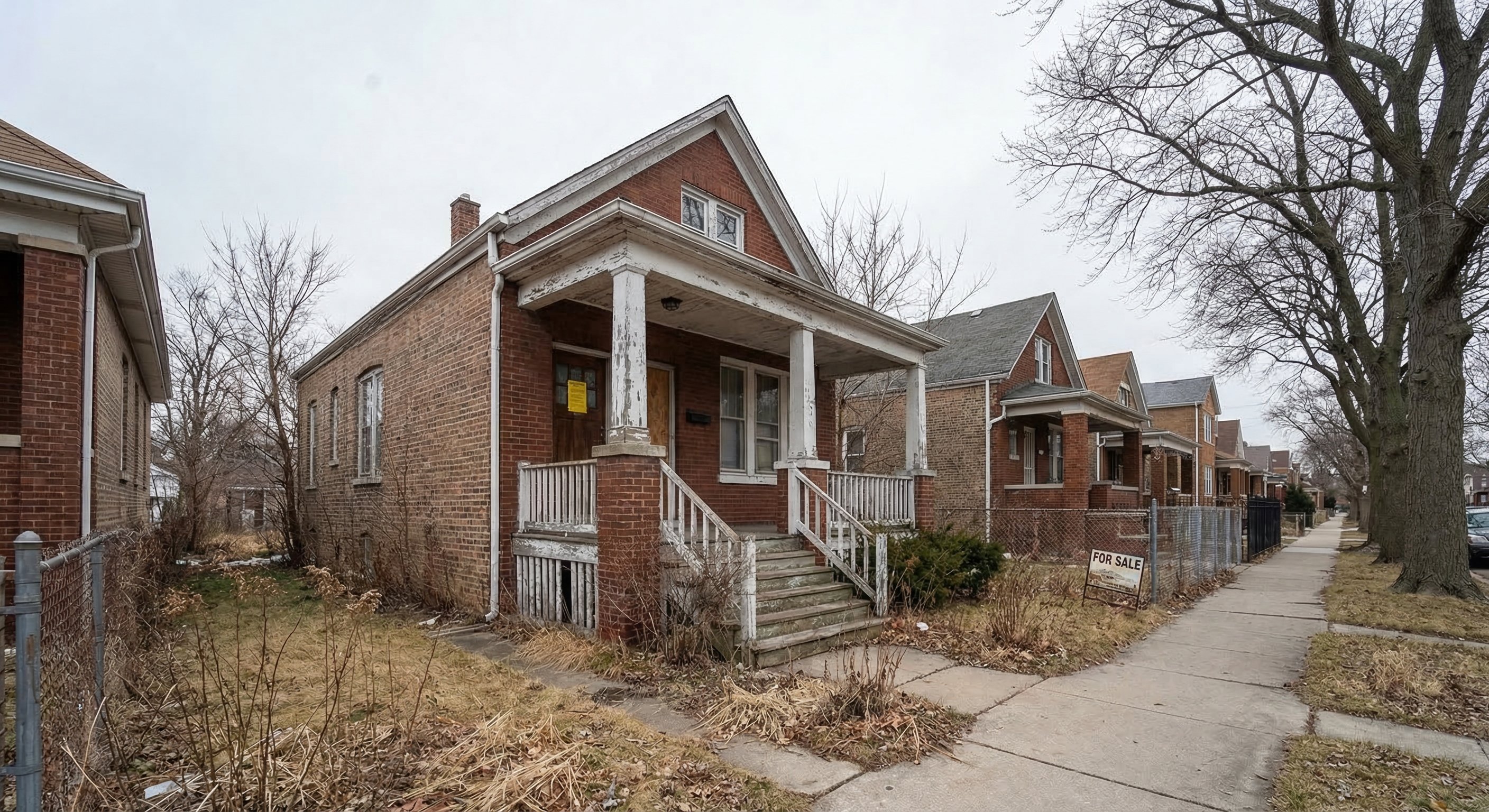 1940s Chicago red brick bungalow on a working-class street — peeling white porch paint, winter-brown overgrown lawn, property tax notice on front door